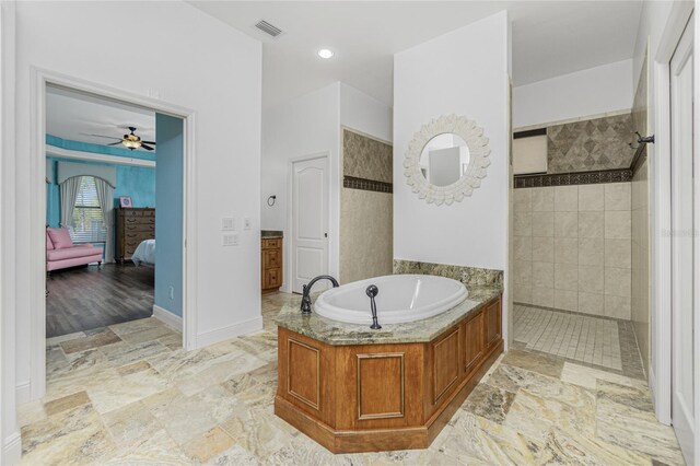 bathroom featuring ceiling fan and plus walk in shower