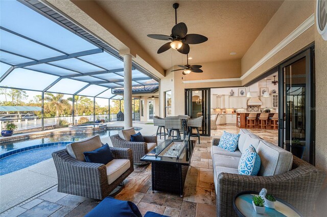 view of patio featuring a lanai, a pool with hot tub, outdoor lounge area, ceiling fan, and a bar