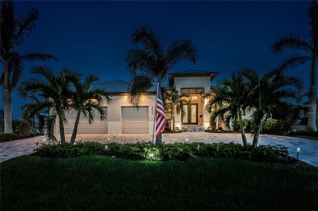 mediterranean / spanish-style house featuring a garage and a lawn