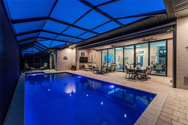 view of pool featuring glass enclosure, a patio, and ceiling fan