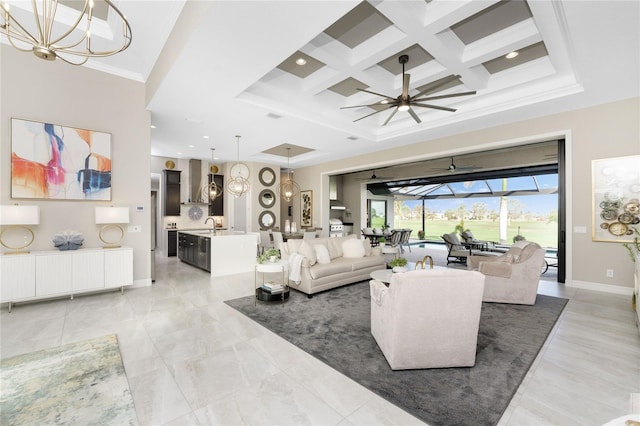 living room featuring ornamental molding, beam ceiling, coffered ceiling, sink, and ceiling fan with notable chandelier