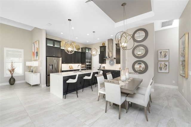 dining room with sink, a raised ceiling, and crown molding