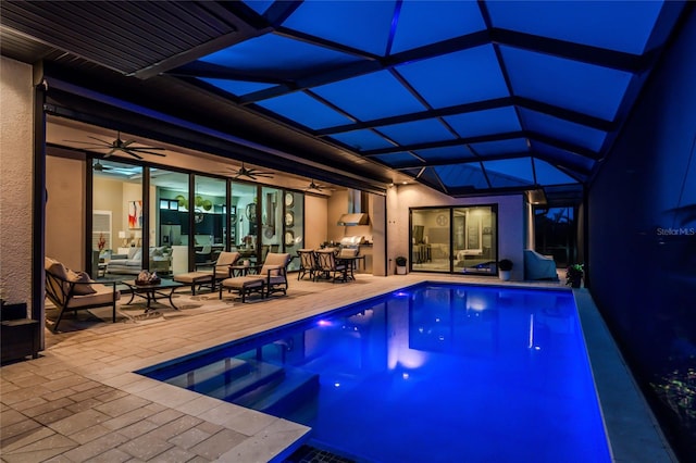 view of pool with a patio, ceiling fan, and glass enclosure