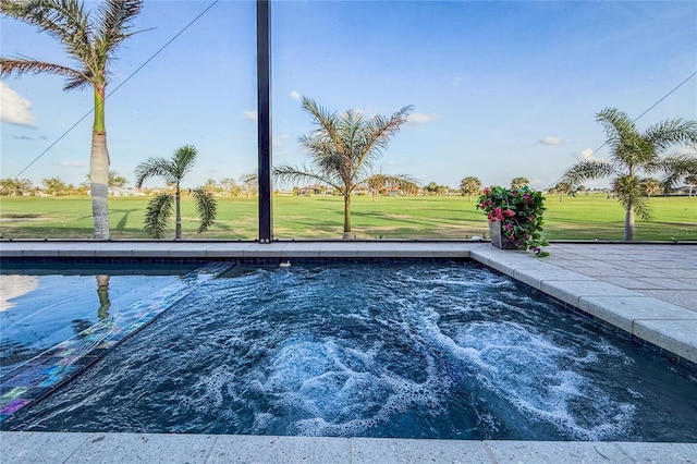 view of swimming pool featuring a yard and a jacuzzi