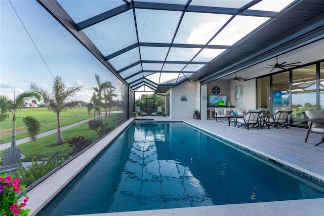 view of swimming pool featuring a lanai, ceiling fan, and a patio area