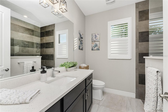 bathroom with tiled shower, toilet, and vanity