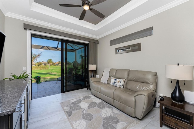 living room featuring ornamental molding, ceiling fan, and a raised ceiling