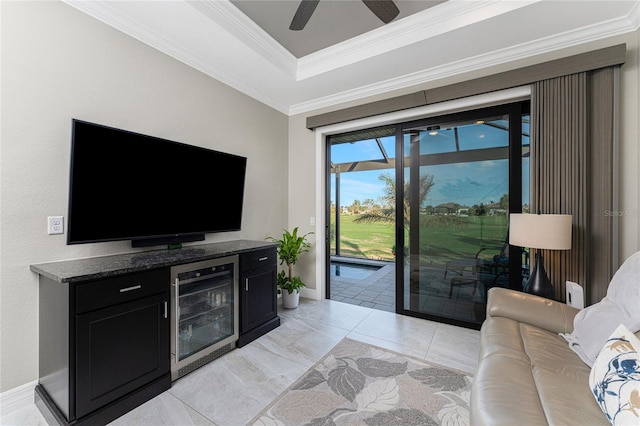 tiled living room with ceiling fan, bar area, wine cooler, and crown molding