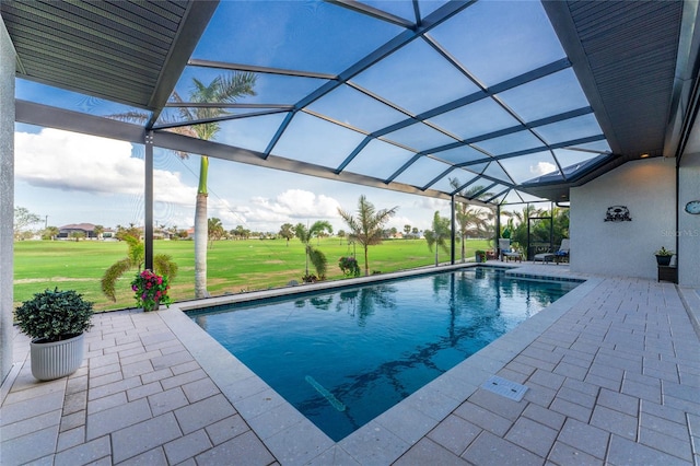 view of swimming pool featuring glass enclosure, a yard, and a patio area