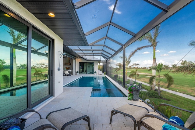 view of pool with a lawn, a lanai, and a patio area