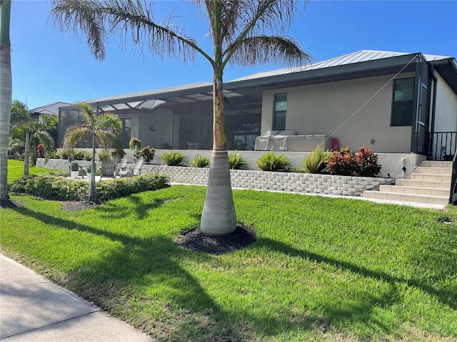 view of side of property featuring glass enclosure and a lawn