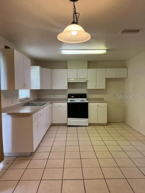 kitchen featuring white range oven, sink, pendant lighting, white cabinetry, and light tile patterned flooring