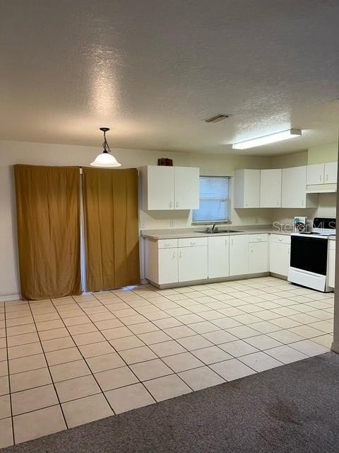 kitchen featuring a textured ceiling, electric stove, white cabinetry, and decorative light fixtures