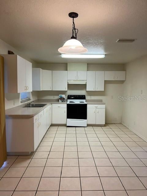 kitchen featuring white cabinets, pendant lighting, white range, and light tile patterned floors