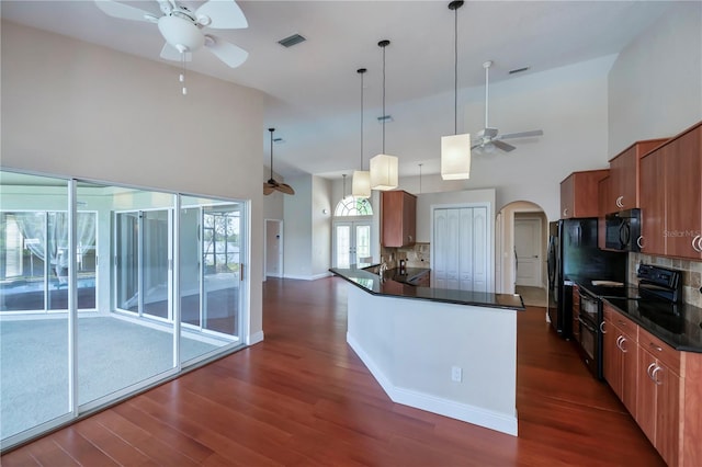 kitchen with hanging light fixtures, high vaulted ceiling, dark hardwood / wood-style floors, decorative backsplash, and black appliances