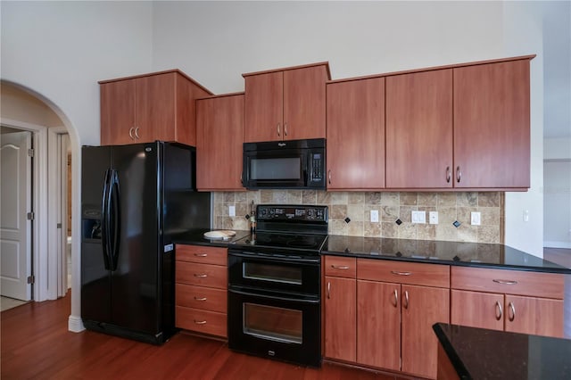 kitchen with black appliances, decorative backsplash, and dark hardwood / wood-style flooring