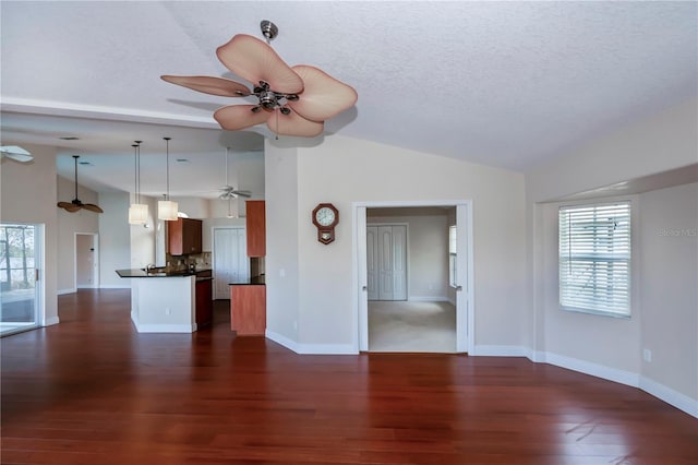 unfurnished living room featuring a textured ceiling, lofted ceiling, dark wood-type flooring, and a wealth of natural light