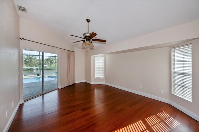 empty room with ceiling fan, dark hardwood / wood-style flooring, and lofted ceiling