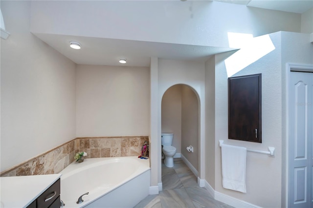 bathroom featuring a bathtub, vanity, and toilet