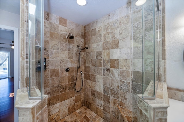 bathroom with hardwood / wood-style flooring, ceiling fan, and tiled shower