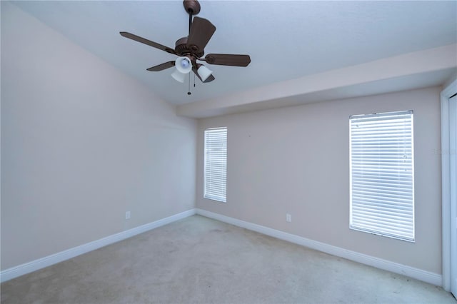 carpeted empty room featuring ceiling fan, a healthy amount of sunlight, and lofted ceiling