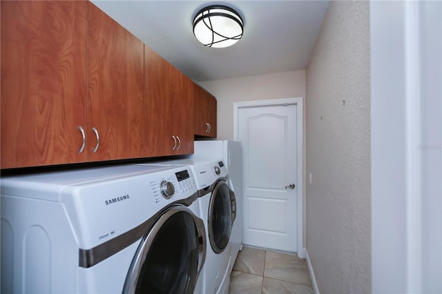 laundry area with light tile patterned floors, cabinets, and independent washer and dryer