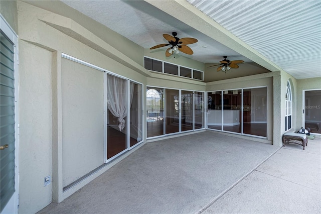 unfurnished sunroom with ceiling fan