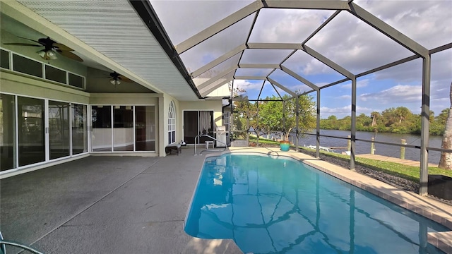 view of swimming pool featuring a patio, a water view, ceiling fan, and a lanai