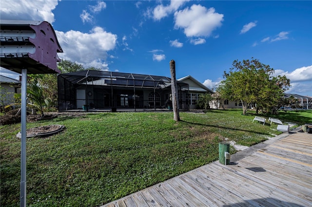 rear view of property with a lawn and glass enclosure