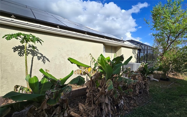 view of side of property featuring glass enclosure and central AC