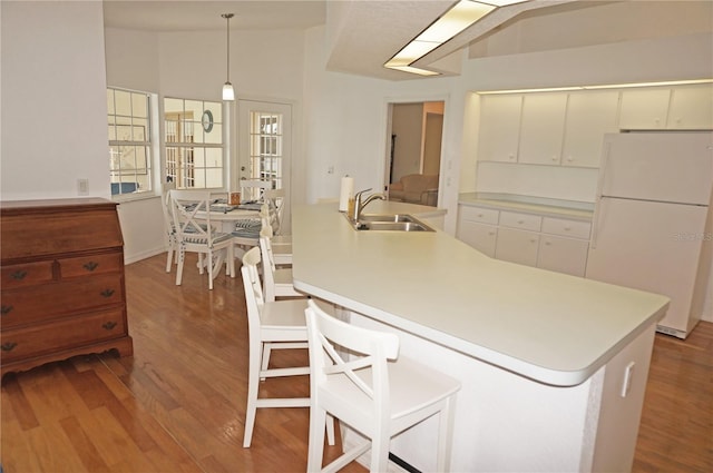 kitchen featuring white cabinetry, white refrigerator, sink, and vaulted ceiling