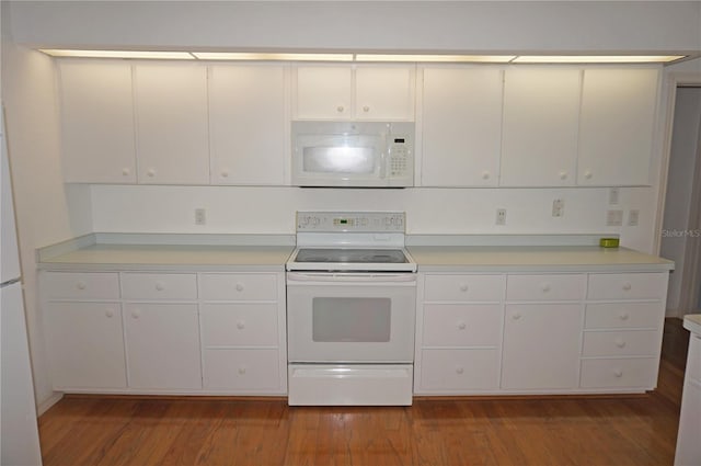 kitchen with dark hardwood / wood-style flooring, white appliances, and white cabinets