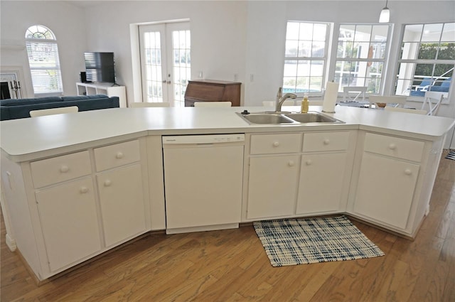 kitchen with dishwasher, white cabinets, plenty of natural light, sink, and light wood-type flooring