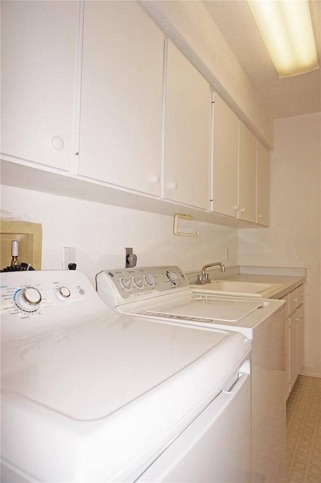 washroom with cabinets, sink, and separate washer and dryer