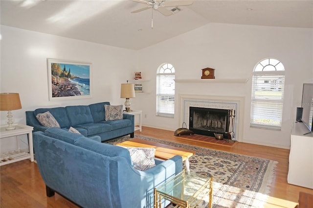 living room featuring ceiling fan, lofted ceiling, wood-type flooring, and a healthy amount of sunlight