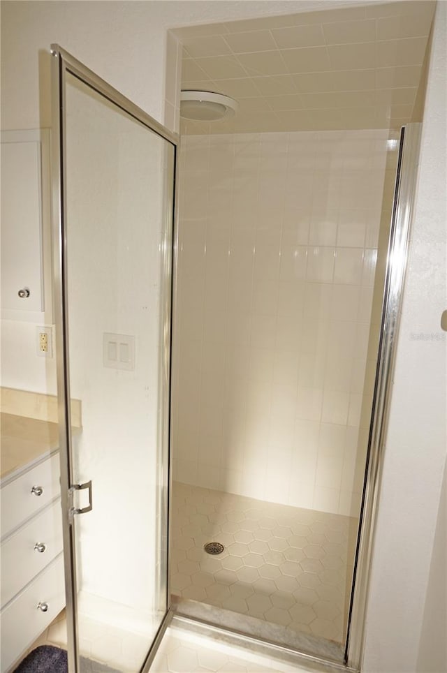 bathroom featuring vanity and a shower with door