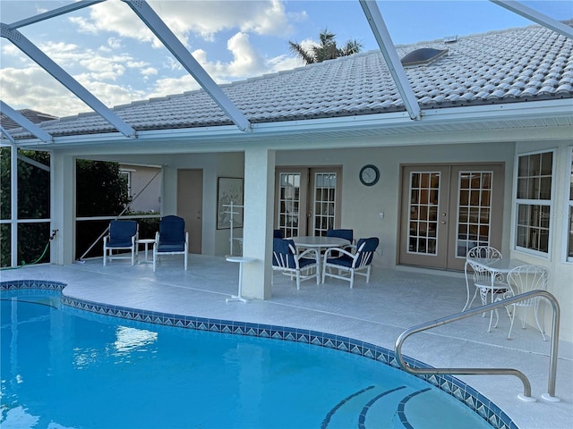 view of pool featuring french doors, glass enclosure, and a patio