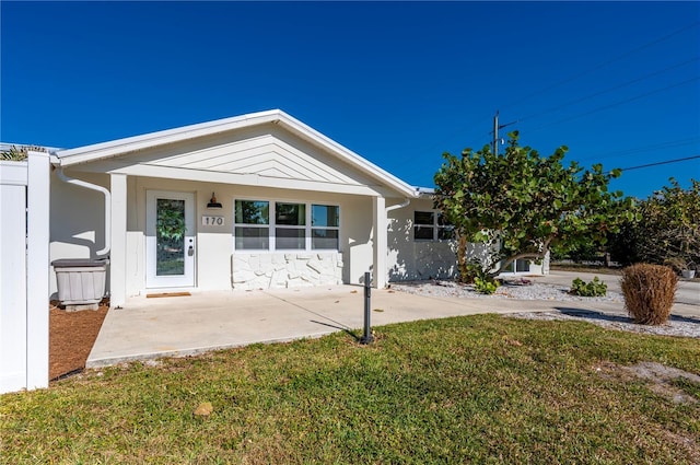 170 Chelsea Ct NW, Port Charlotte, FL 33952 - back of house featuring a lawn and stucco siding