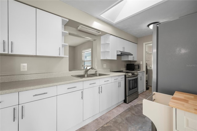 kitchen featuring sink, white cabinetry, stainless steel appliances, and a skylight