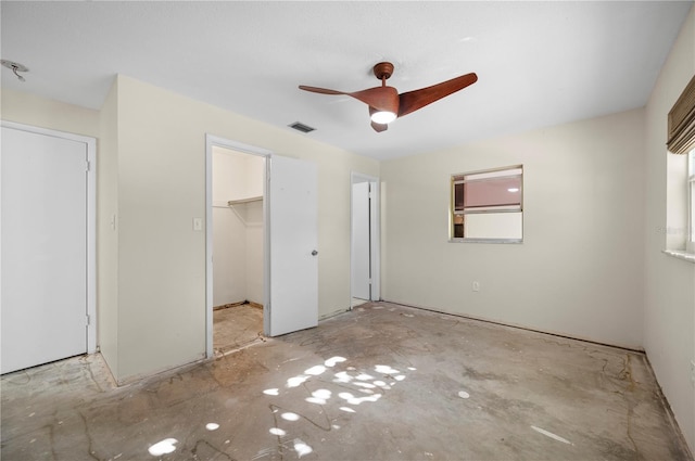 unfurnished bedroom featuring ceiling fan, a closet, and a spacious closet