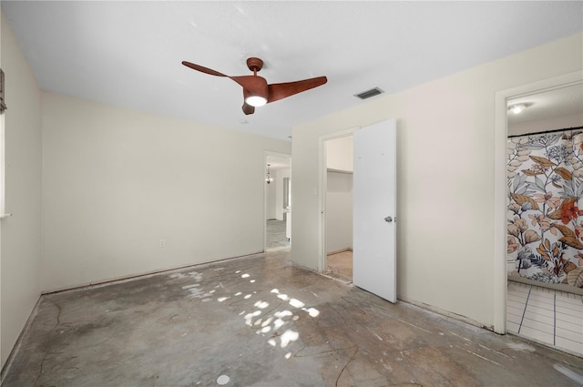 unfurnished bedroom featuring a closet, a spacious closet, ceiling fan, and ensuite bathroom