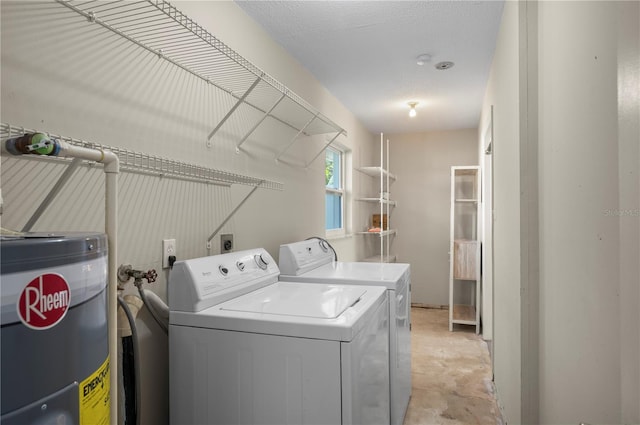 washroom with washing machine and dryer, electric water heater, and a textured ceiling