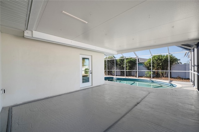 view of pool featuring glass enclosure and a patio