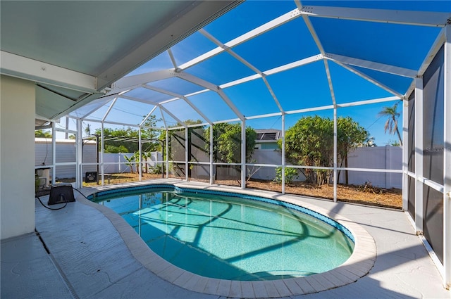 view of pool featuring glass enclosure and a patio area