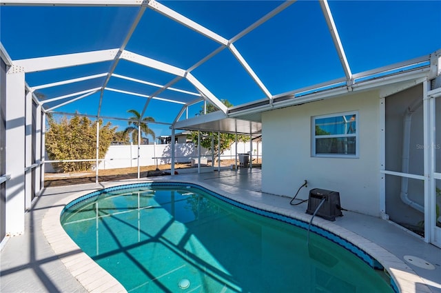 view of swimming pool featuring glass enclosure and a patio area