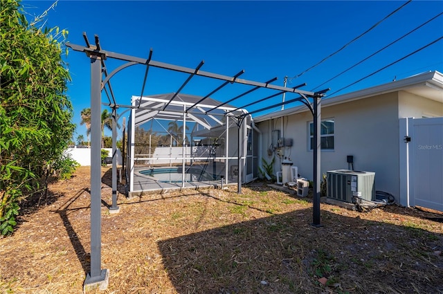 view of yard featuring glass enclosure and central AC unit