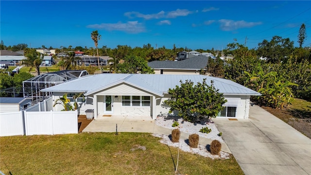 view of front of house featuring a lanai and a front lawn