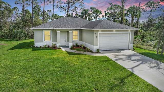 ranch-style home with a garage and a yard