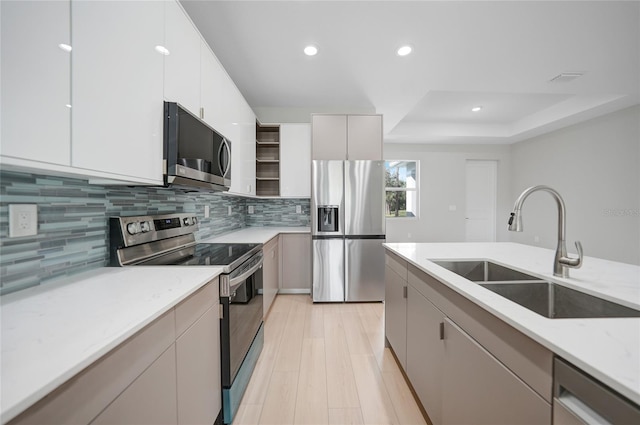 kitchen featuring white cabinetry, appliances with stainless steel finishes, sink, and light hardwood / wood-style floors