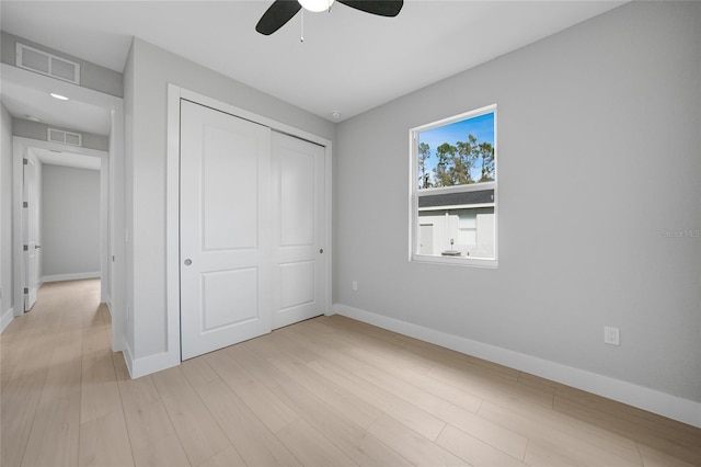 unfurnished bedroom featuring light hardwood / wood-style floors, ceiling fan, and a closet